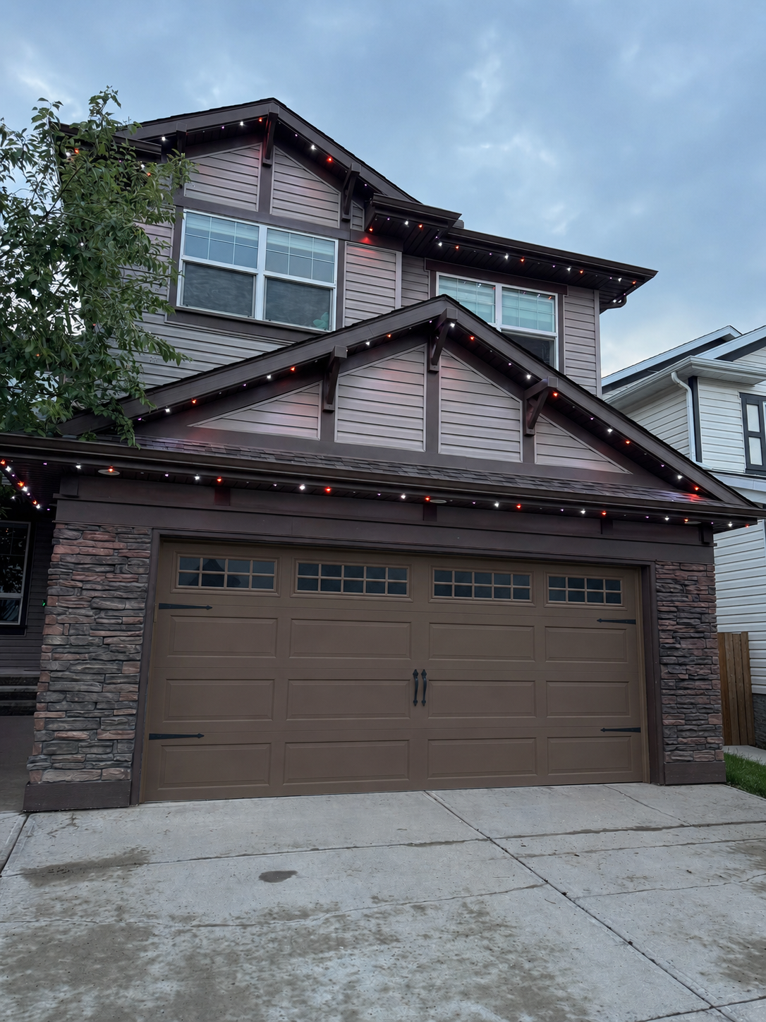 Permanent LED purple lighting installation on a home exterior at dusk